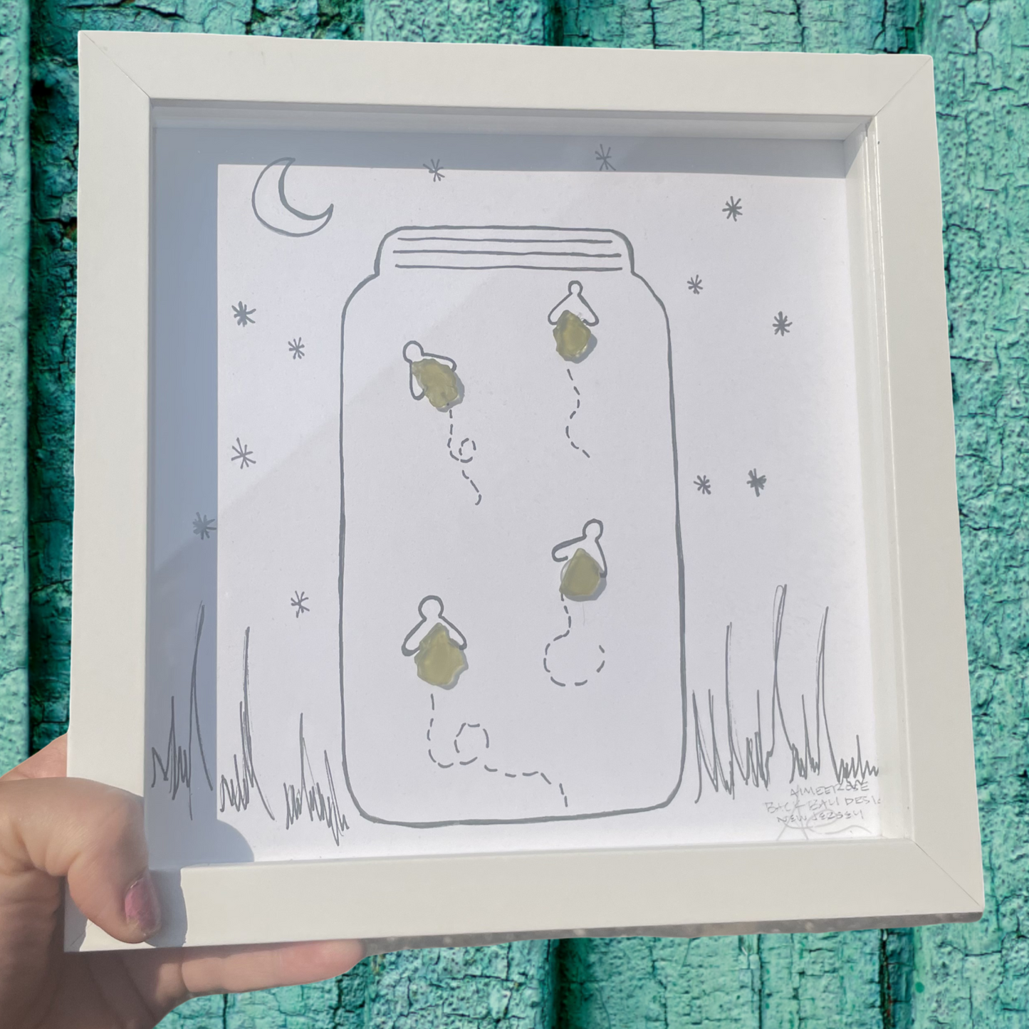 Framed illustration of a jar with plants fireflies sea glass art