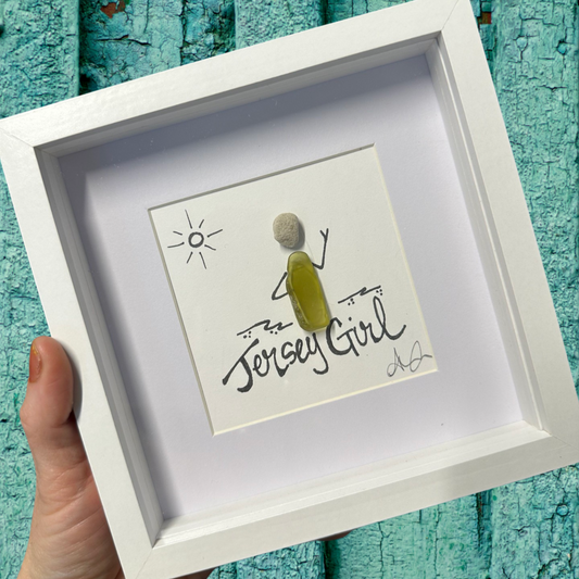 A 6x6 shadowbox with plexiglass, featuring a cartoon-style illustration of a character with 'Jersey girl' text, held by a hand against a blue background.
