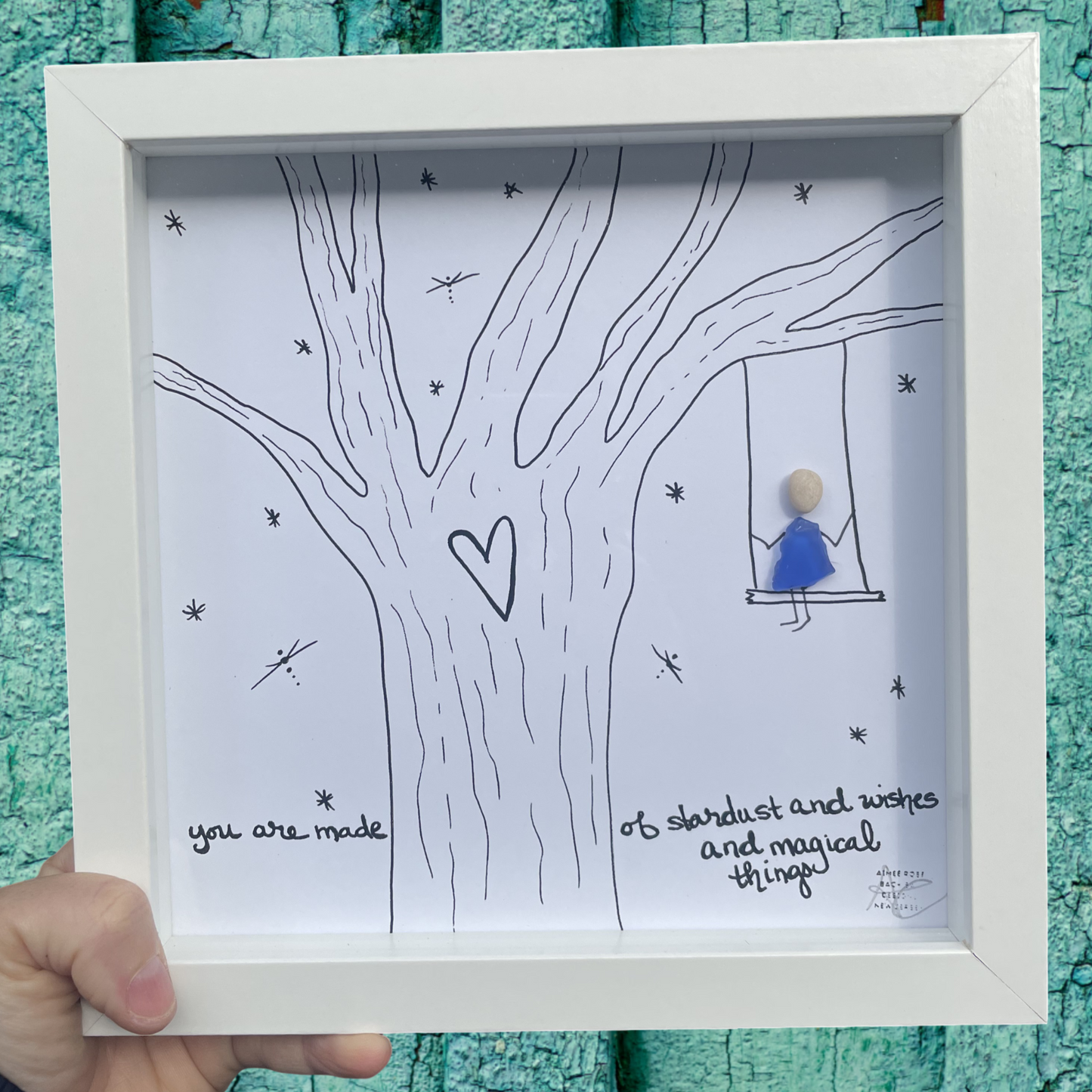 Framed artwork with a tree design and text, you are made of stardust and wishes and magical things