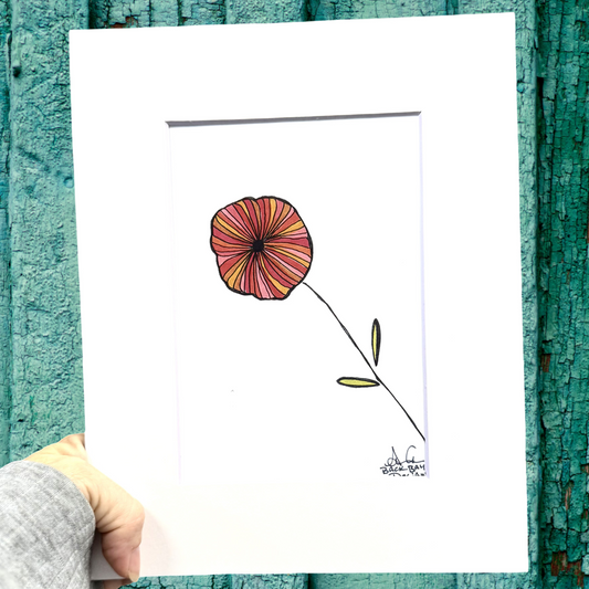 Hand holding a print with a red flower illustration against a textured teal background