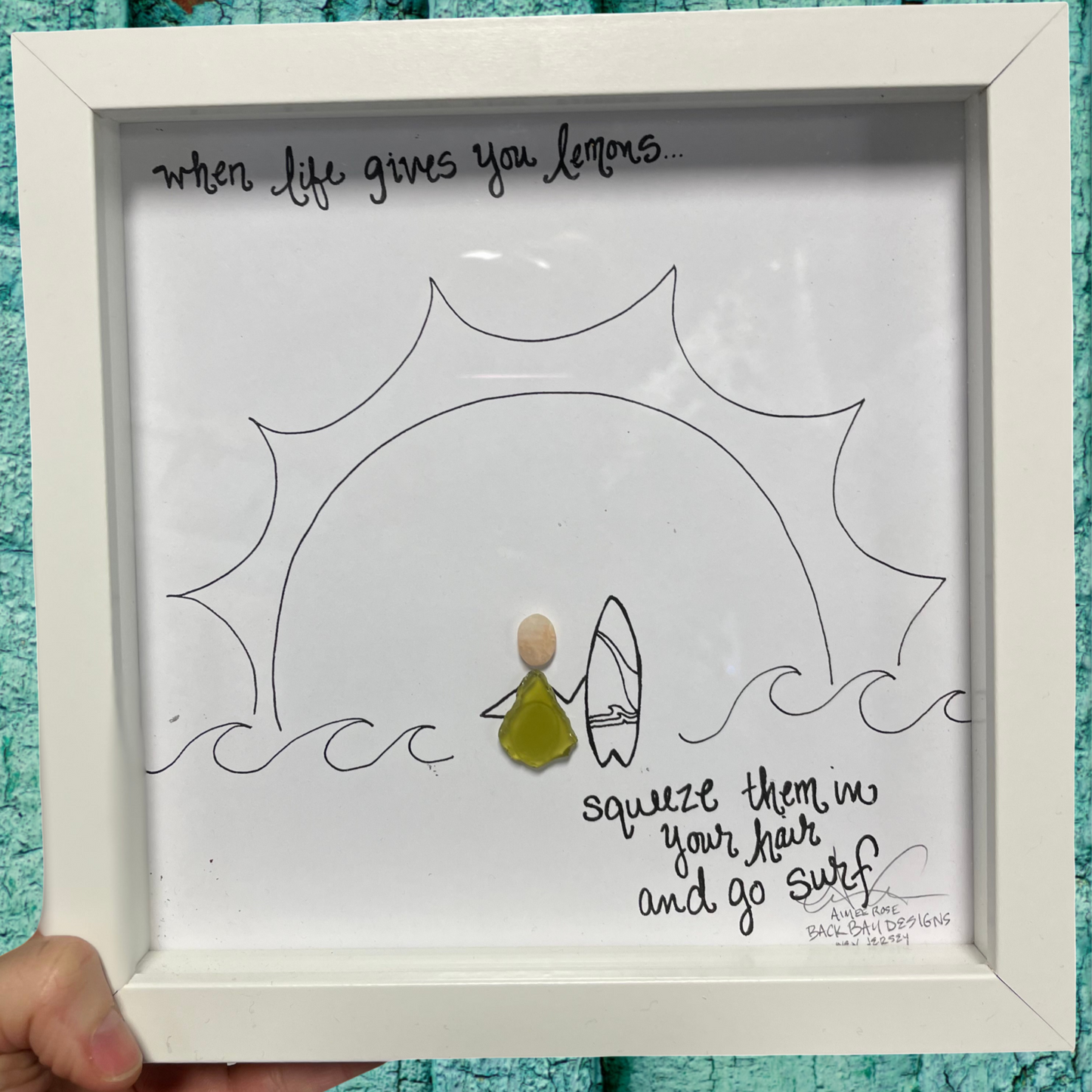 Framed artwork with a person holding a surfboard and text when life gives you emons squeeze them in your hair and go surf Lemon_Surf_Original_8_inch_Seaglass sea glass art 