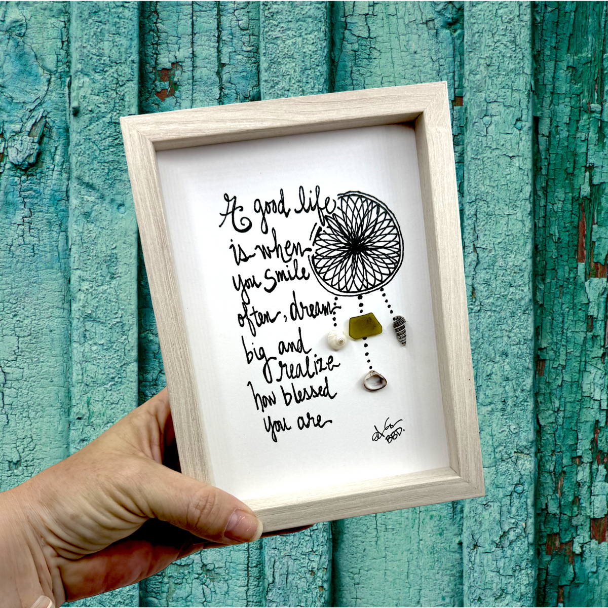 Quote: "A good life is when you smile often, dream big and realize how blessed you are" Image: Hand-drawn dreamcatcher with sea glass and seashells hanging from beaded strands
