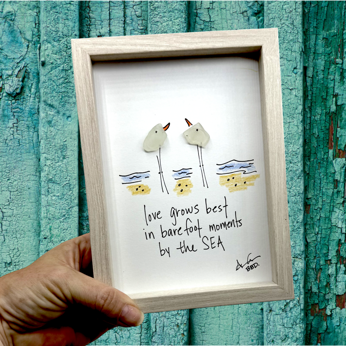 Quote: "love grows best in barefoot moments by the SEA" Image: Two sea glass birds facing each other on a hand-drawn colorful beach with waves and sand
