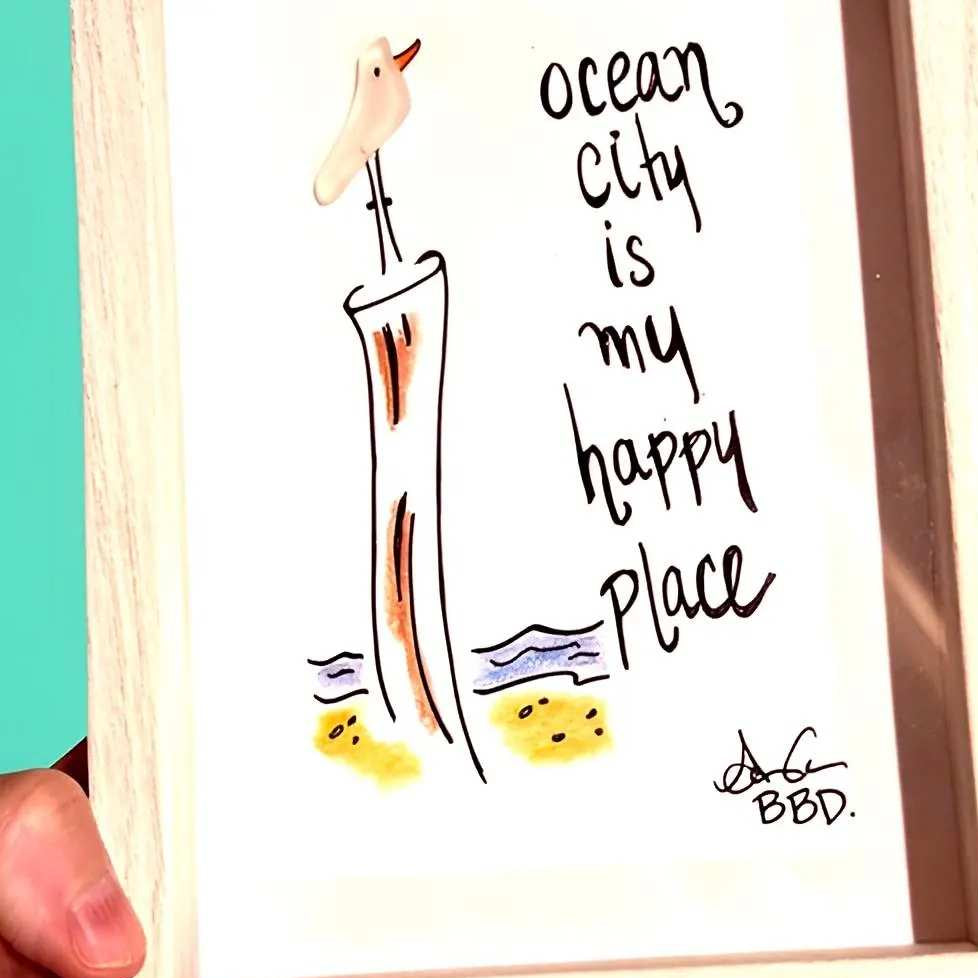 oceancityismyhappyplacebrighter_ZOOM "ocean city is my happy place" sea glass seabird perched on hand drawn wood piling on colorful beach with waves