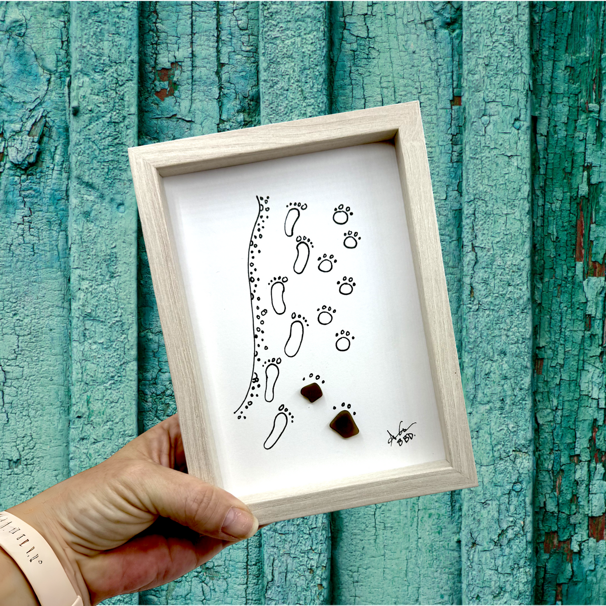 Quote: Image only, no words, beyond words Image: Hand-drawn human footprints and paw prints along the water's edge, with sea glass paw prints