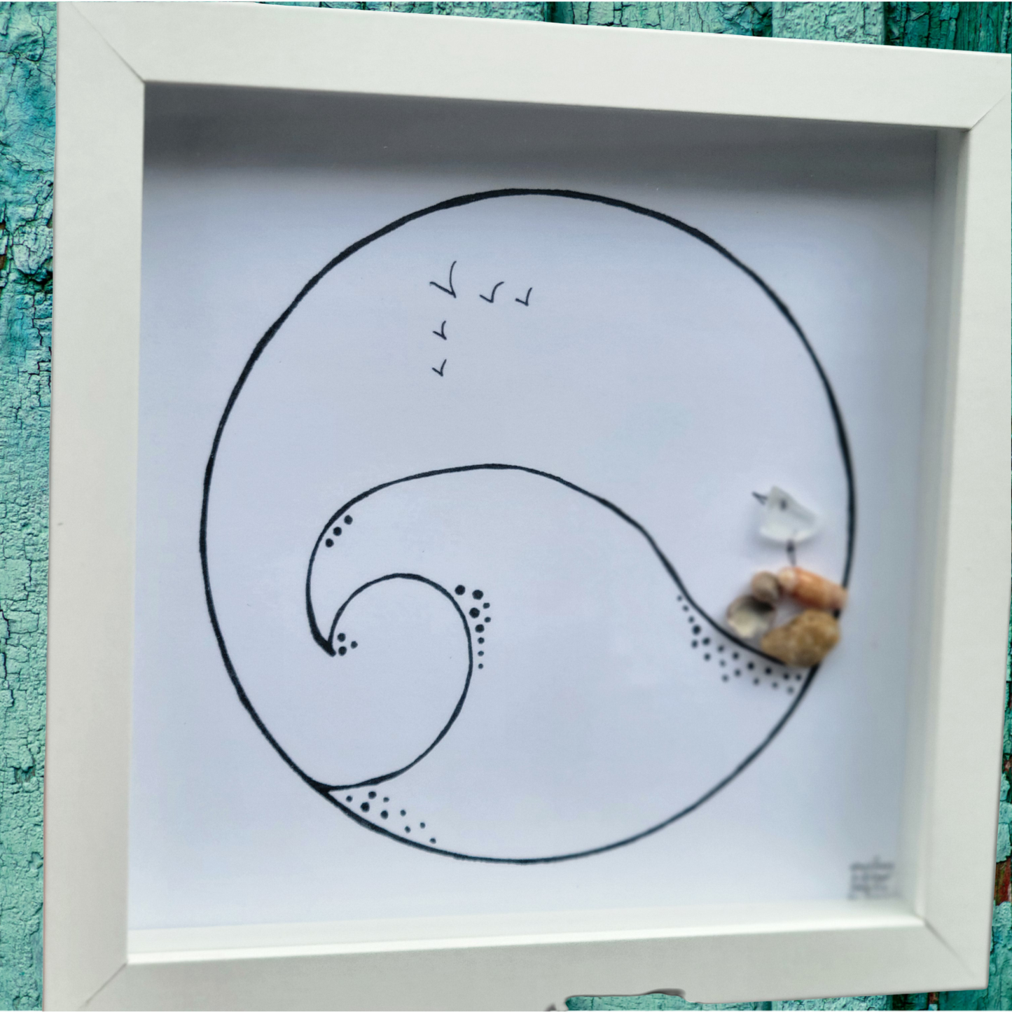 Framed artwork with a wave design and sea glass art
