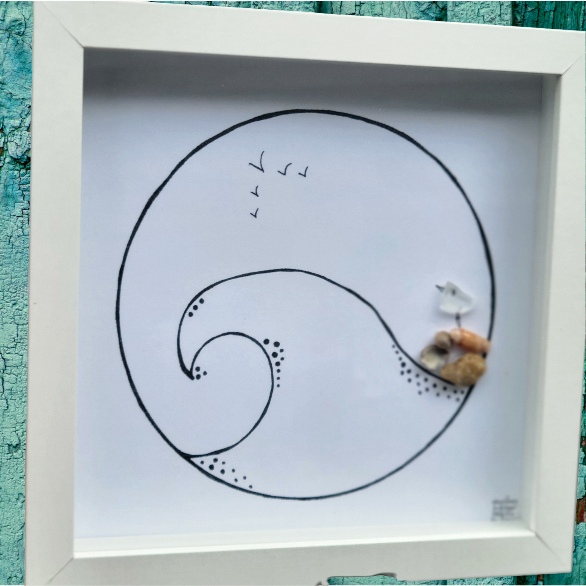 Framed artwork with a wave design and sea glass art