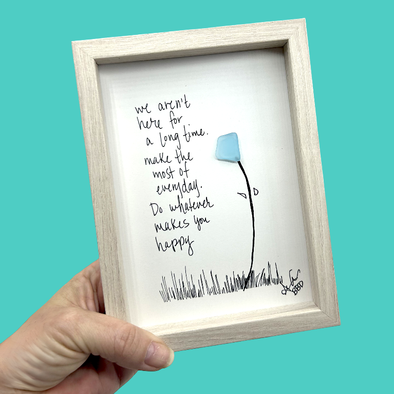 Quote: "we aren't here for a long time. make the most of everyday. Do whatever makes you happy" Image: Single sea glass flower on a tall curved hand-drawn stem with tiny leaves, rising from hand-drawn grass
