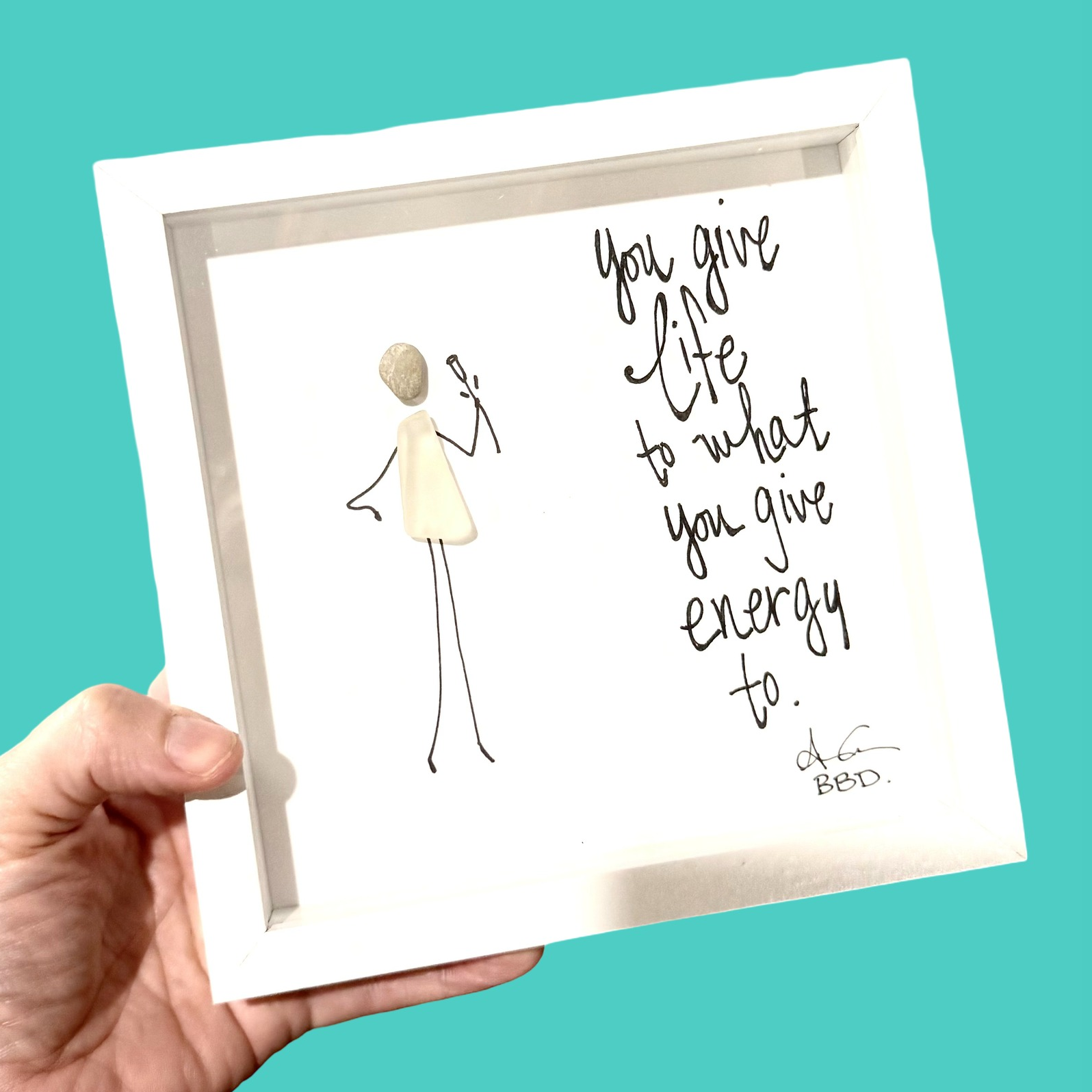 "You give life to what you give energy to" Sea glass person with hand on hip lifting hand drawn  flower to face to smell the scent 